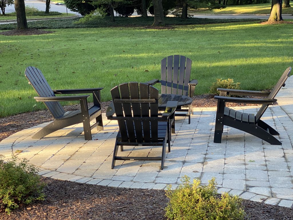Extension of a paver patio with 4 Adirondack chairs.