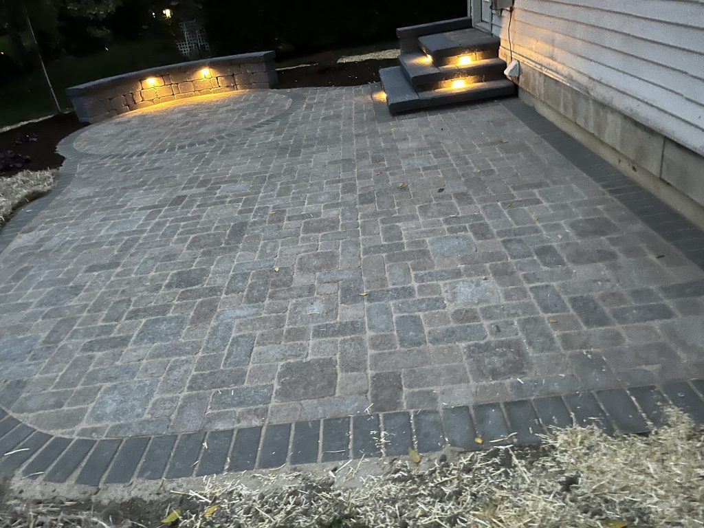 Paver Patio in a back yard in Ann Arbor with landscape lighting. installed.