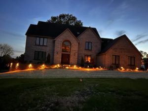 Photo of a large 2 story brick house with updated lighting.