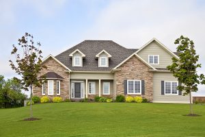 A modern brick home with a beautifully landscaped front yard. 