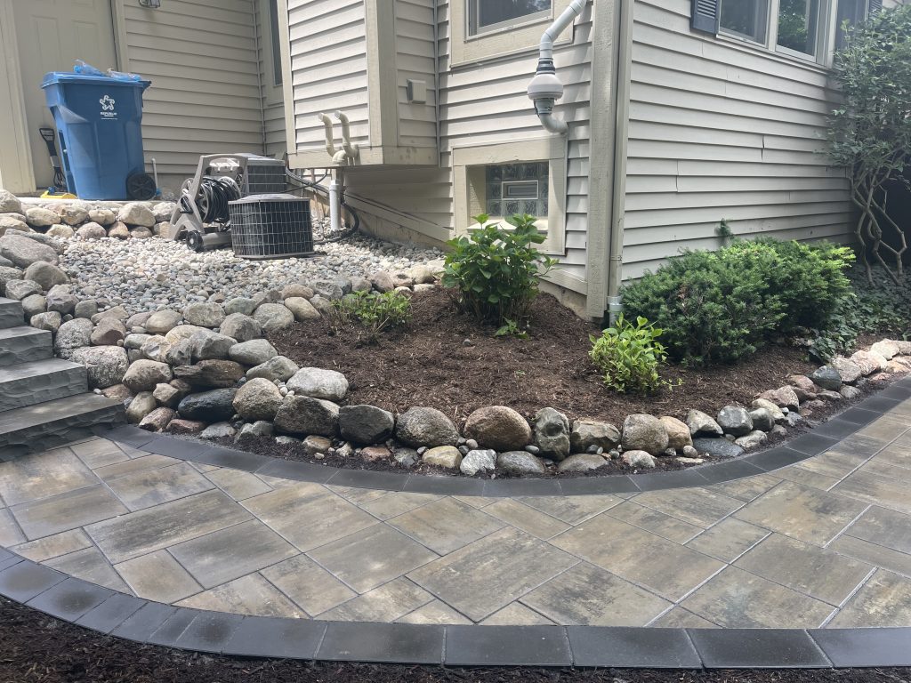 Installed brick paver walkway and a stone boulder border
