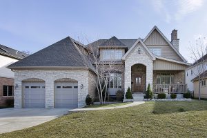 Modern stone and brick home with a professionally maintained, landscaped front yard. 