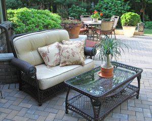 Modern brick patio with stylish furnishings and well-maintained landscape design. 