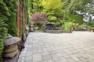 Backyard garden with Asian inspired paver patio and pond. 