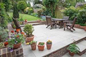 Beautifully landscaped yard with large stone patio. 